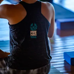 Back of a black tank top with the Five Parks Yoga logo during a class
