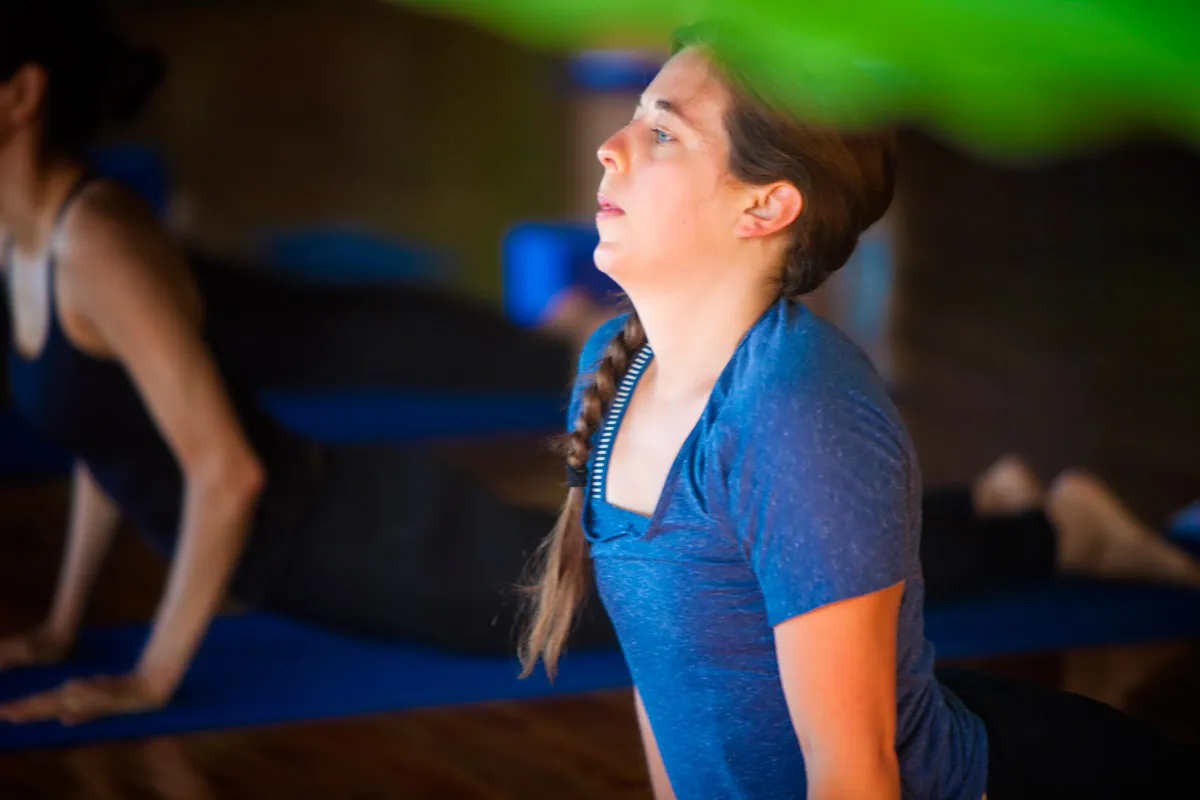Retreat guest with a braid gazing upward during a yoga class