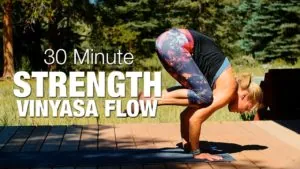 Class thumbnail: 30 Minute Strength Vinyasa Flow, woman in crow pose on a deck