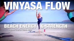 Class thumbnail: Vinyasa Flow Beach Energy and Strength, woman in a standing split on a beach