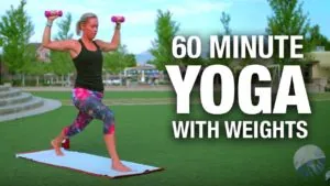 Class thumbnail: 60 Minute Yoga with Weights, woman in a lunge holding dumbbells in a park