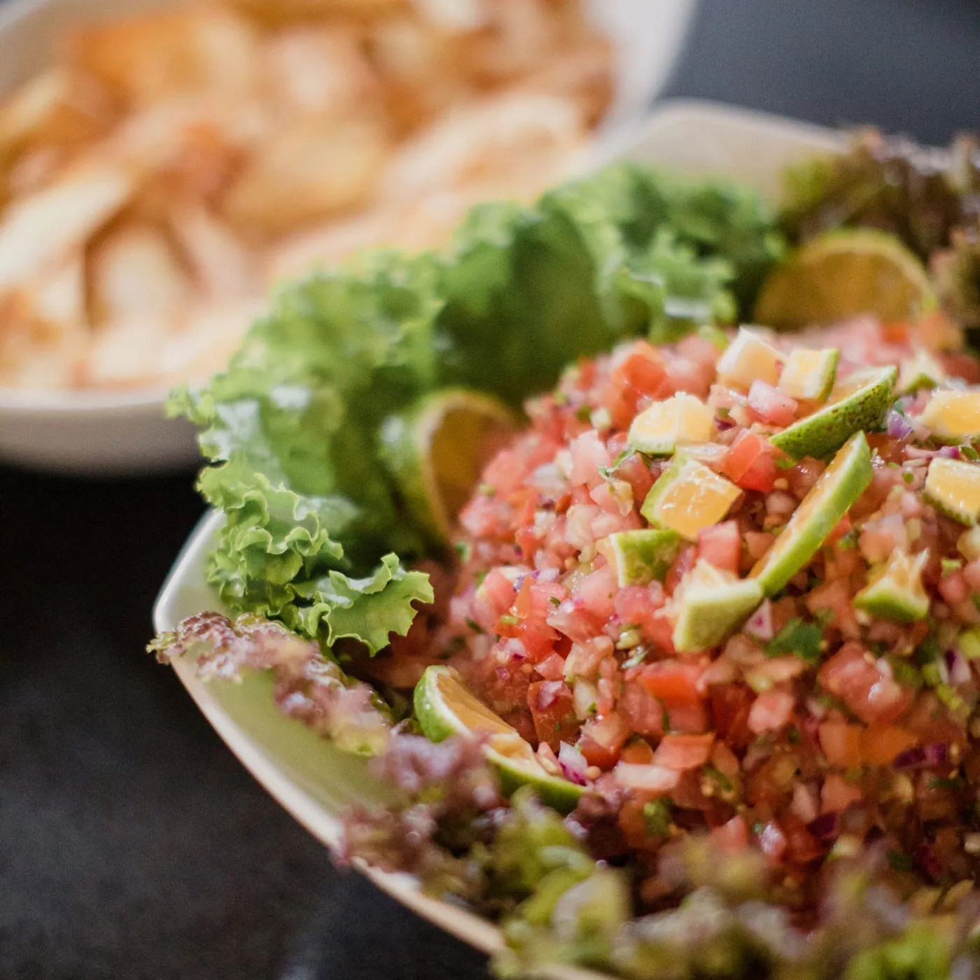 Fresh tomato salsa salad on lettuce with lime slices