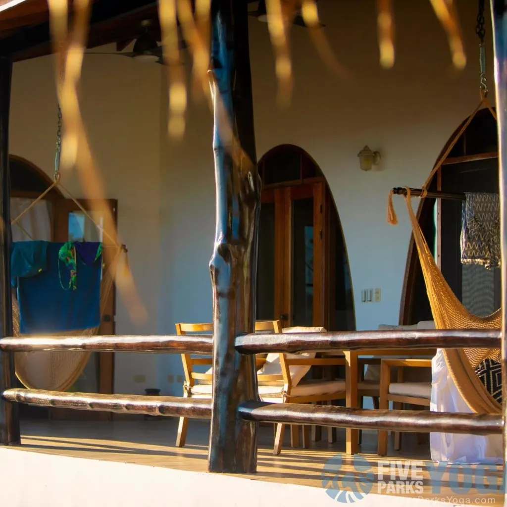 Open porch with a hammock and wooden railing