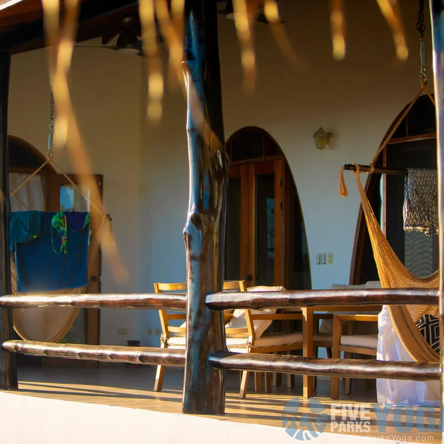 Open porch with a hammock and wooden railing