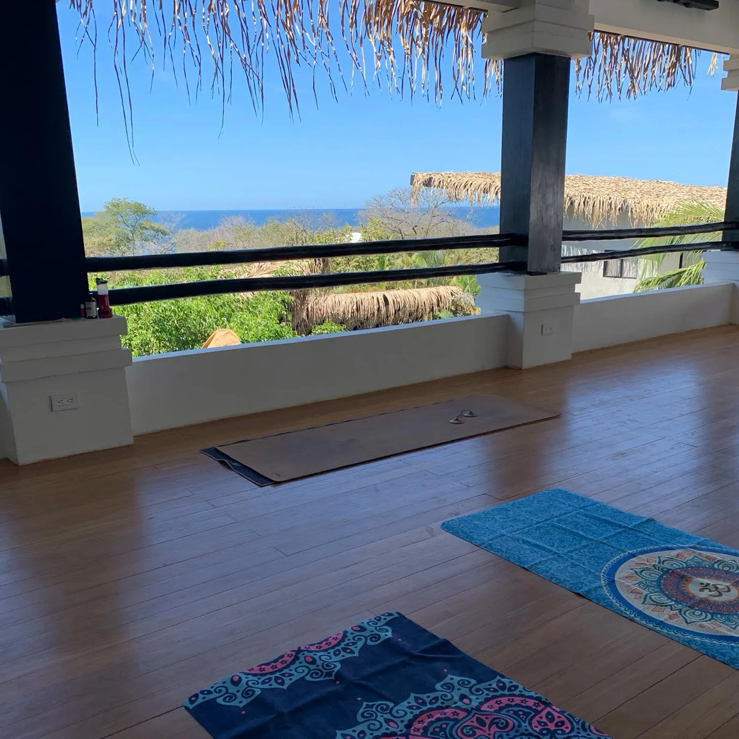 Empty yoga studio with mats and an ocean view