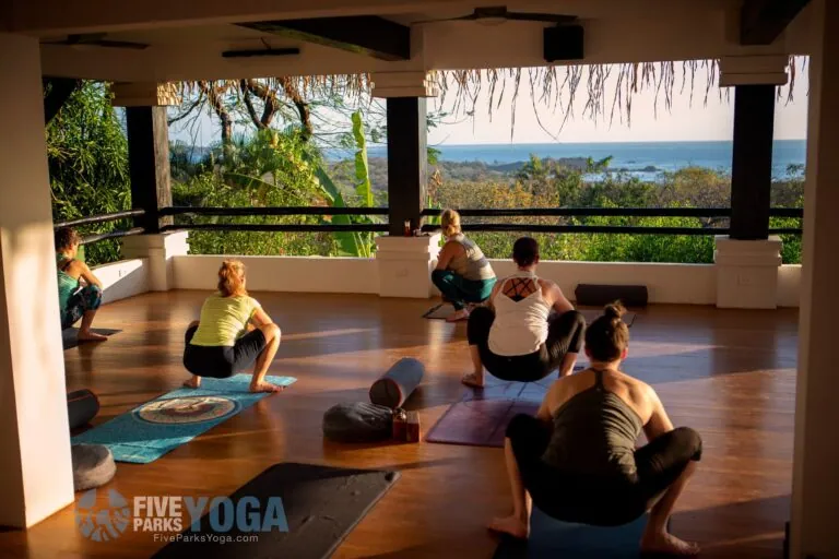 Guests in yoga poses on an open deck overlooking the ocean