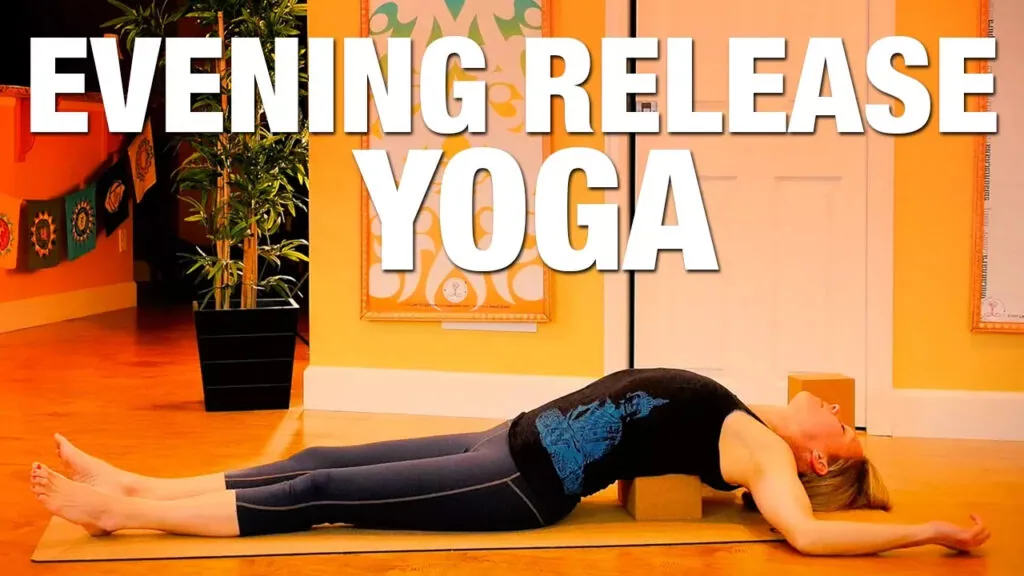 Evening release yoga, woman lying back on a mat in a warm orange room
