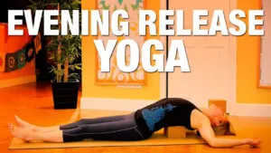 Evening release yoga, woman lying back on a mat in a warm orange room