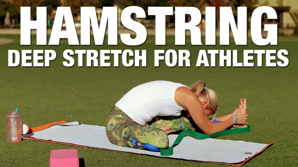Hamstring deep stretch for athletes, woman in a seated forward fold on a grass lawn