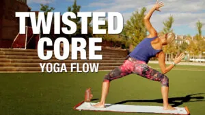 Twisted Core yoga flow, woman in a lunge twist on a mat outdoors