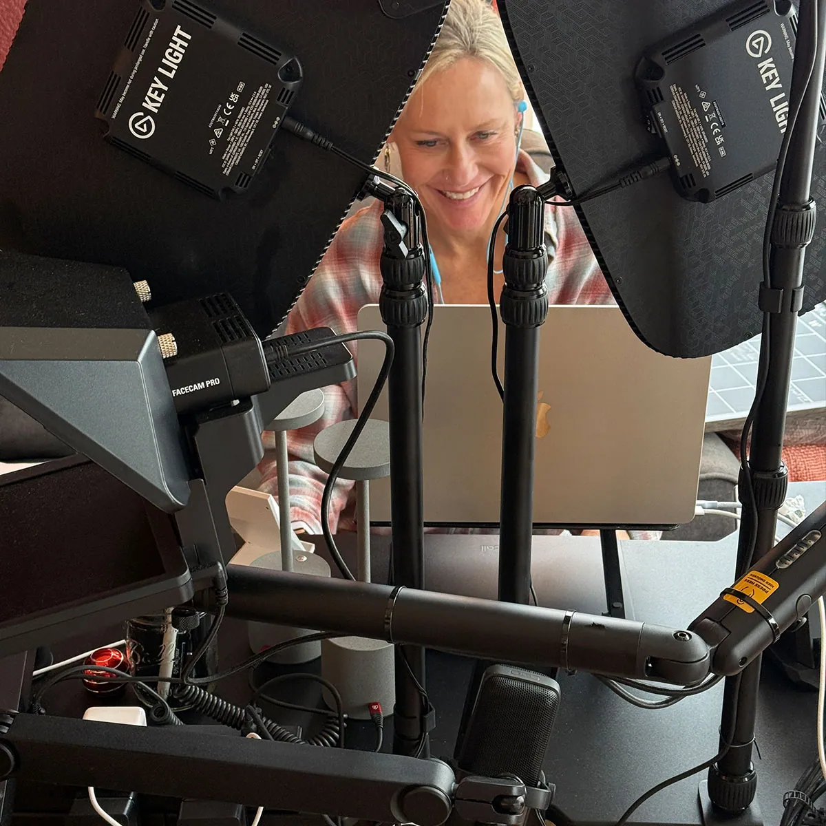Erin Sampson at a laptop between two key lights in the studio