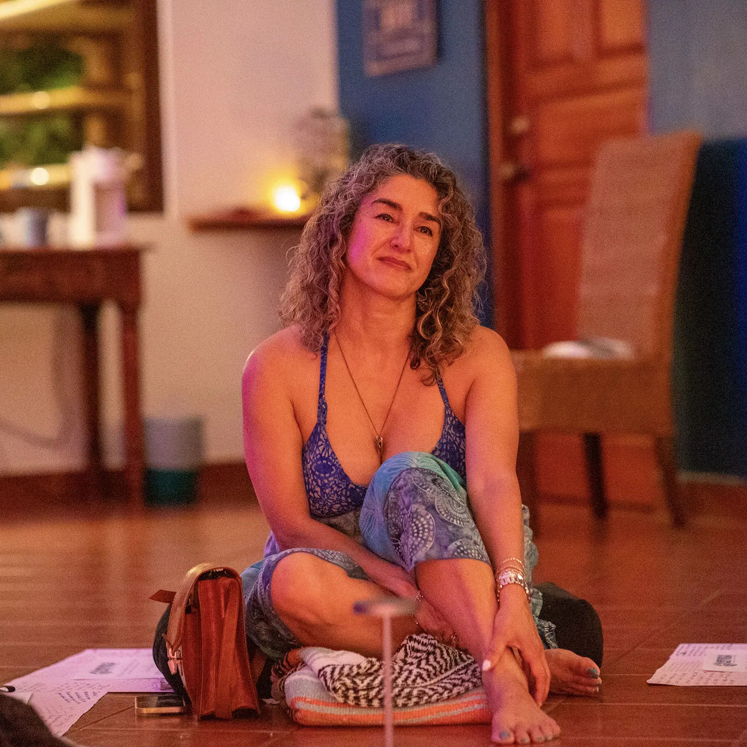Smiling woman sitting on the floor in a studio with warm light