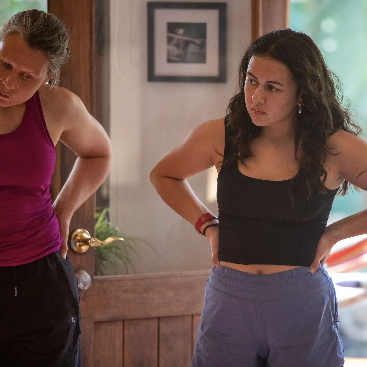 Two teacher training students standing with hands on hips in a doorway